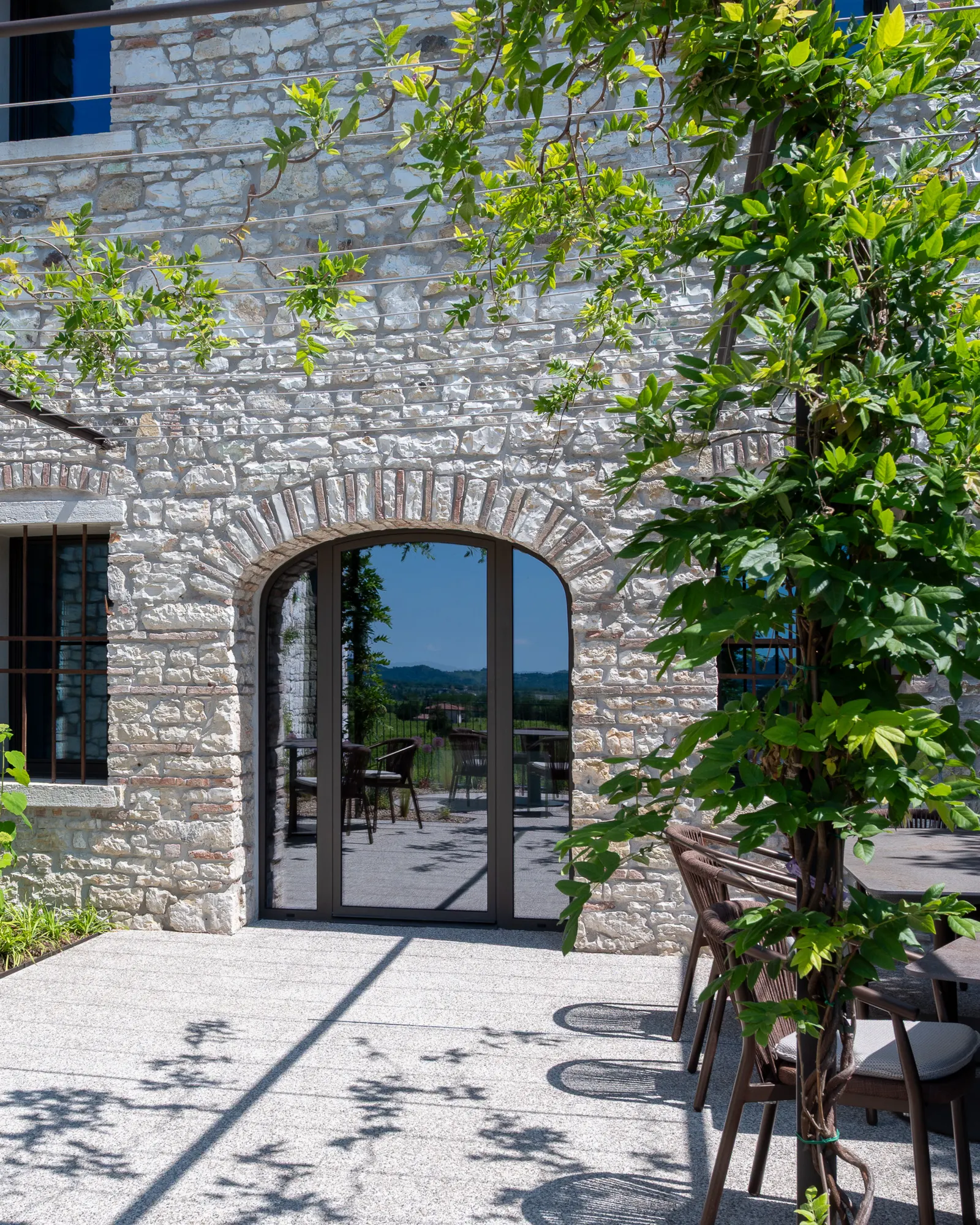Corte interna del Relais Borgo Taurino con arco in pietra e giardino fiorito