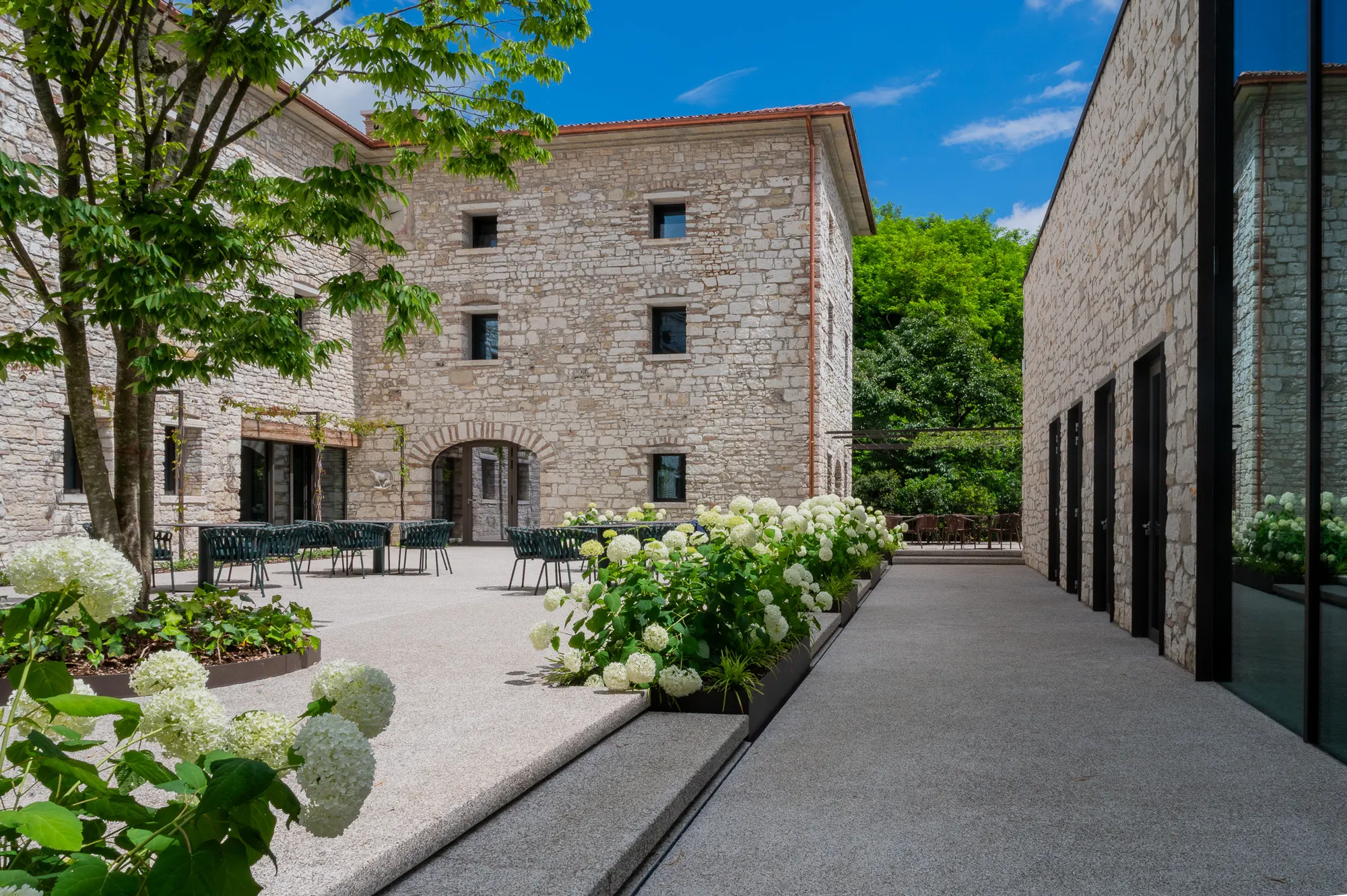 Corte del Relais Borgo Taurino con sentiero fiorito di ortensie